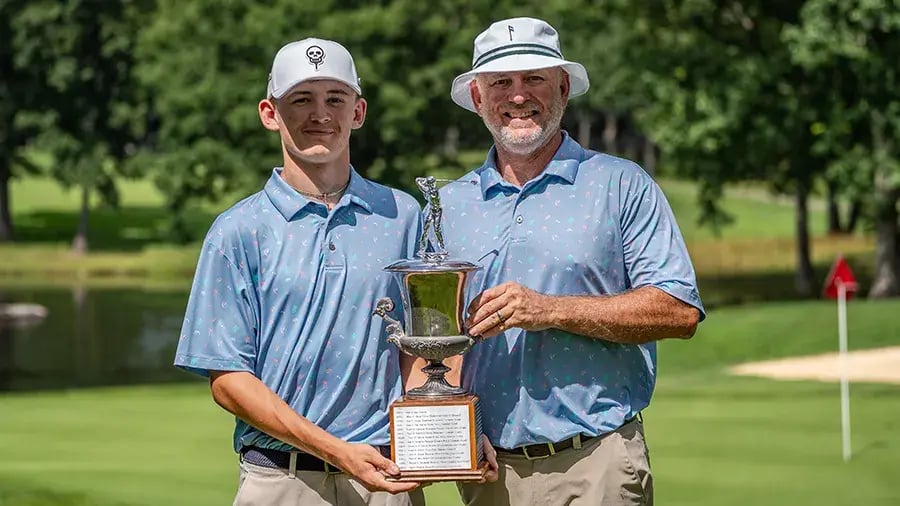 father son golf team with trophy