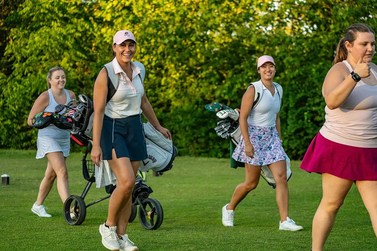 group of young female golfers walking smiling