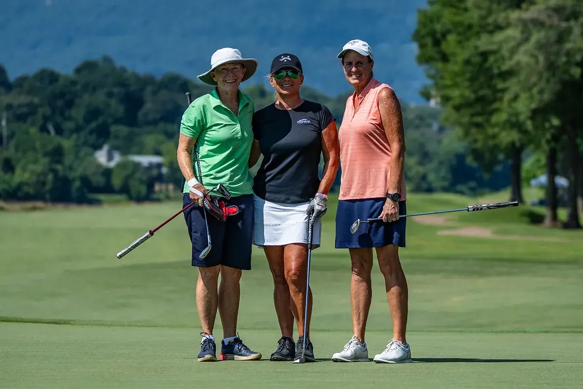 three female golfers posing in a row