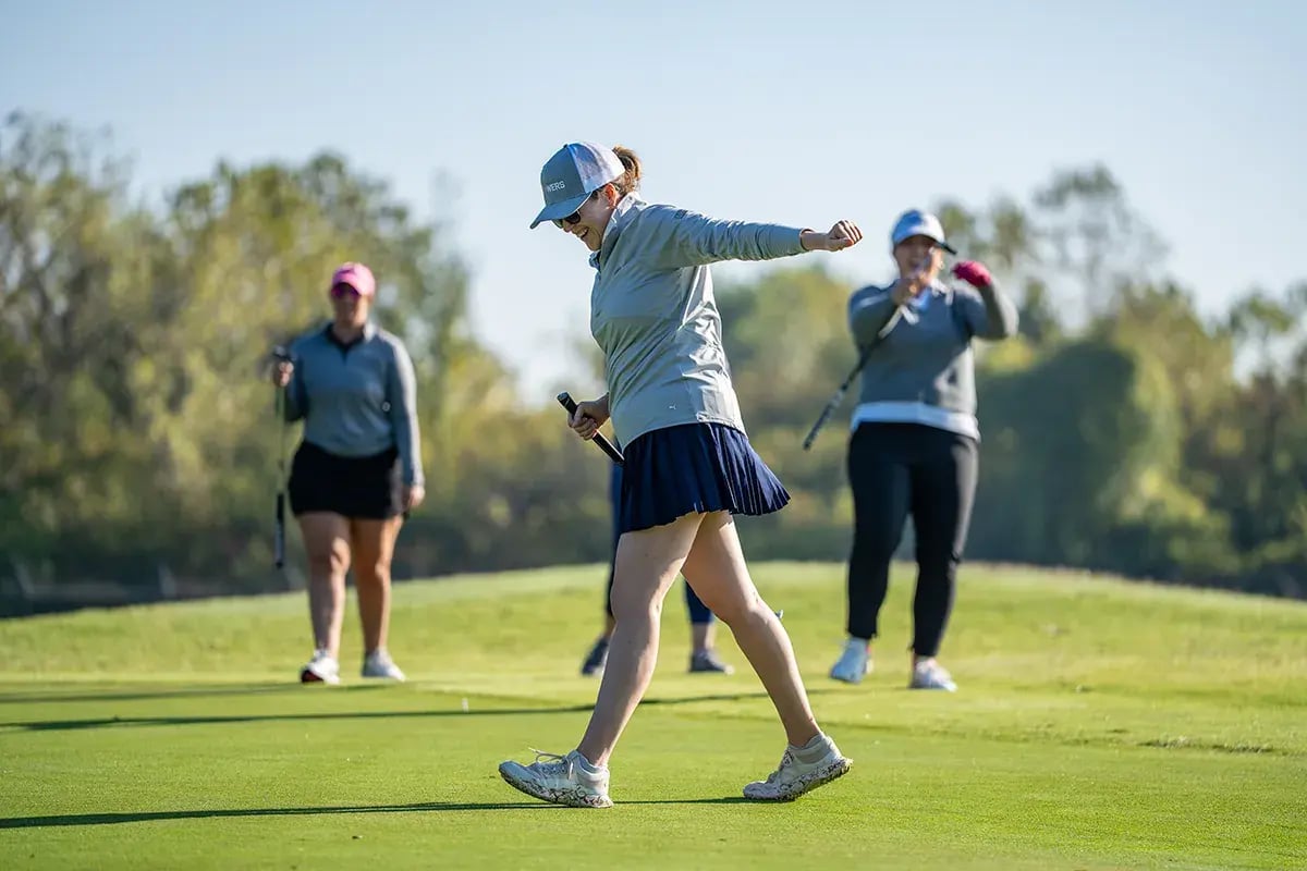 three female golfers walking stretching