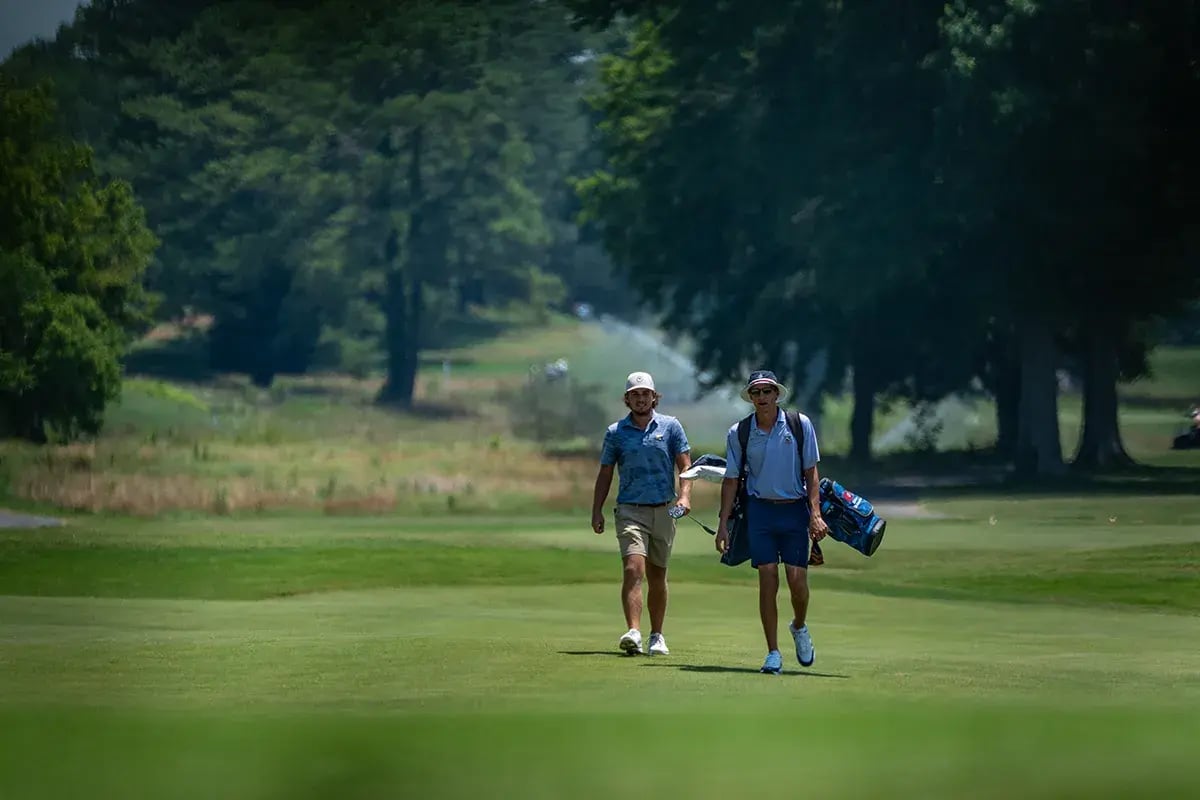 two male golfers walking talking