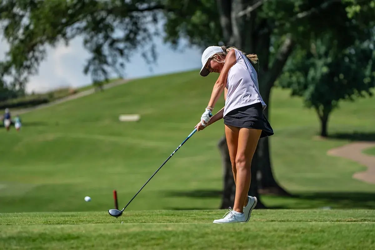 young female golfer hitting ball